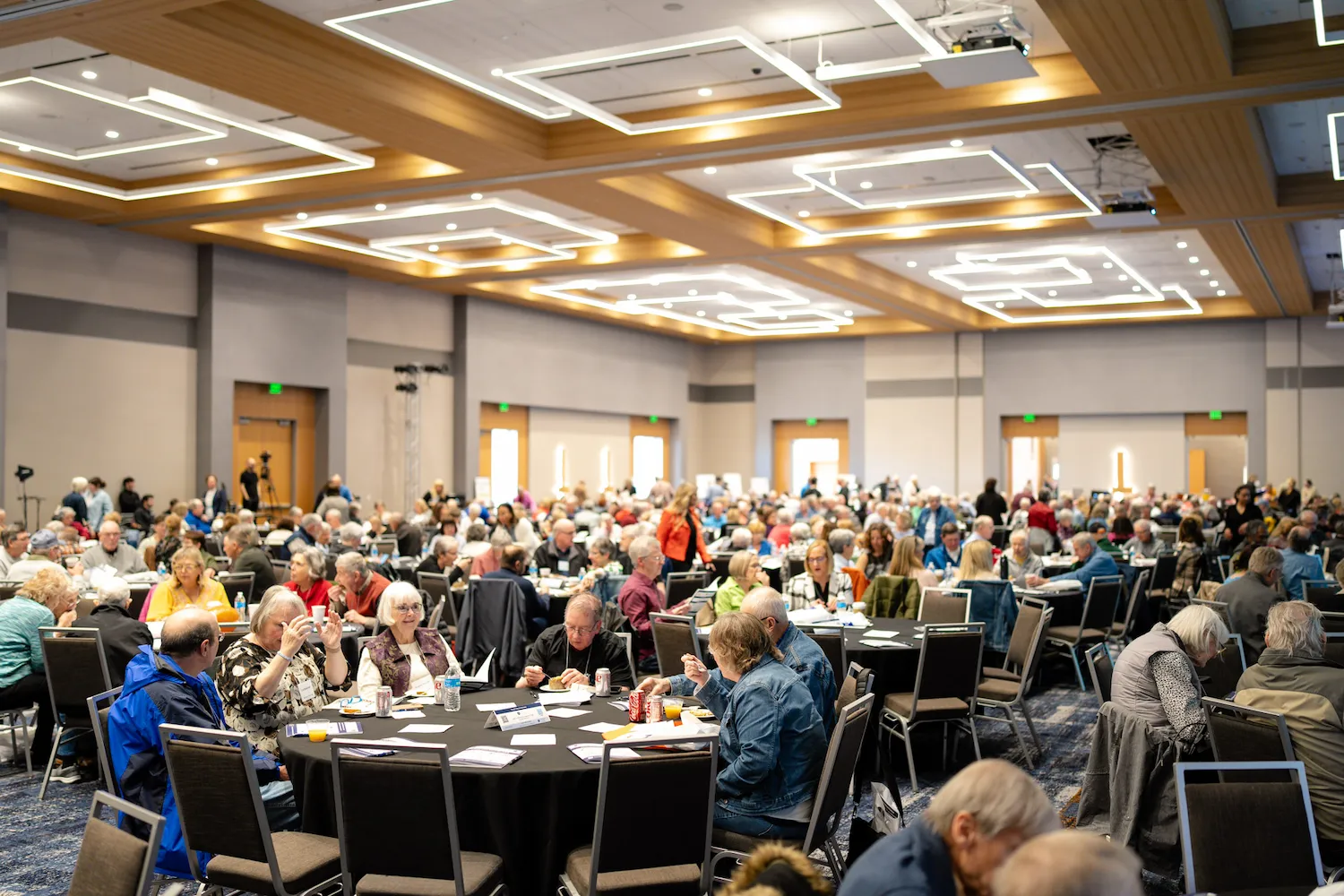 Large group of attendees seated at round tables at the WPA Symposium and the Brookfield Conference Center.