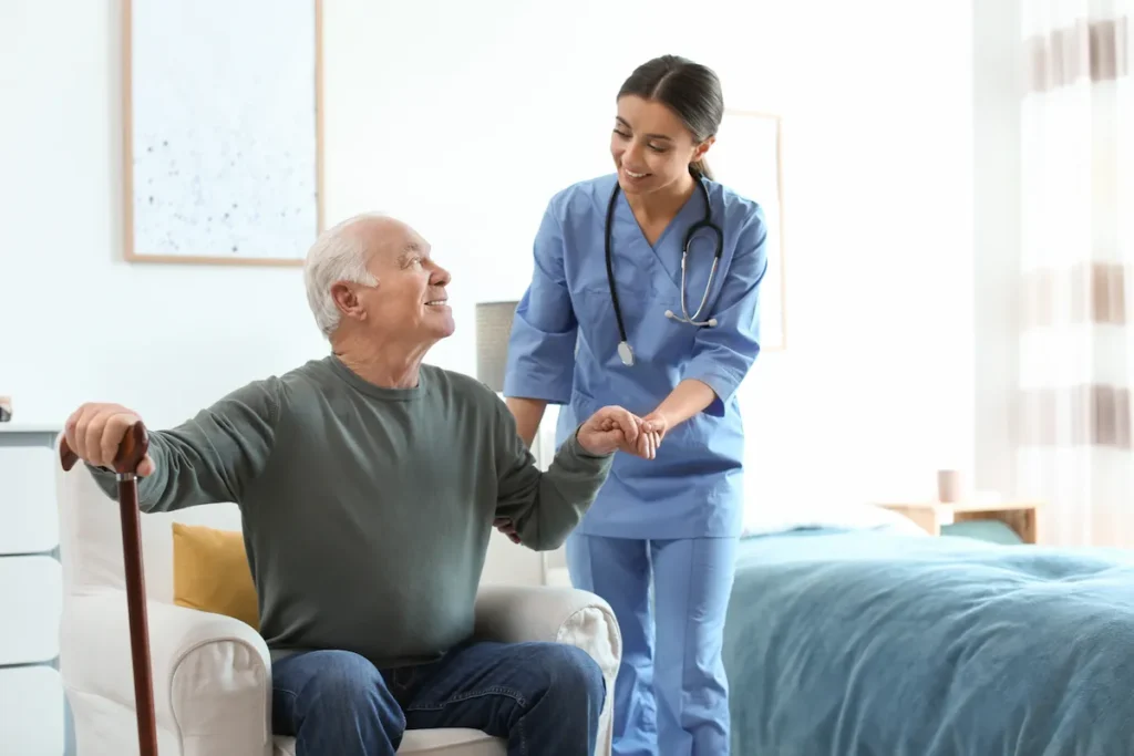 Caretaker helps elderly man stand up