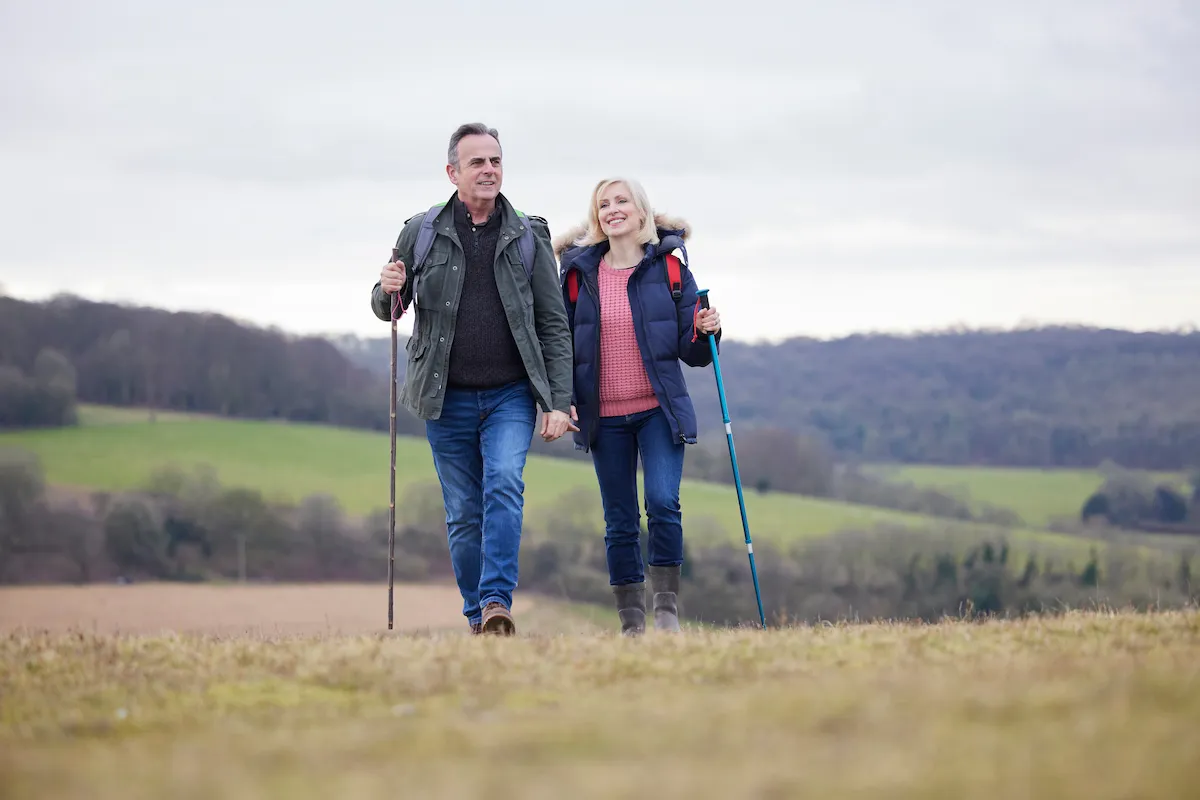 Older couple hiking in a field