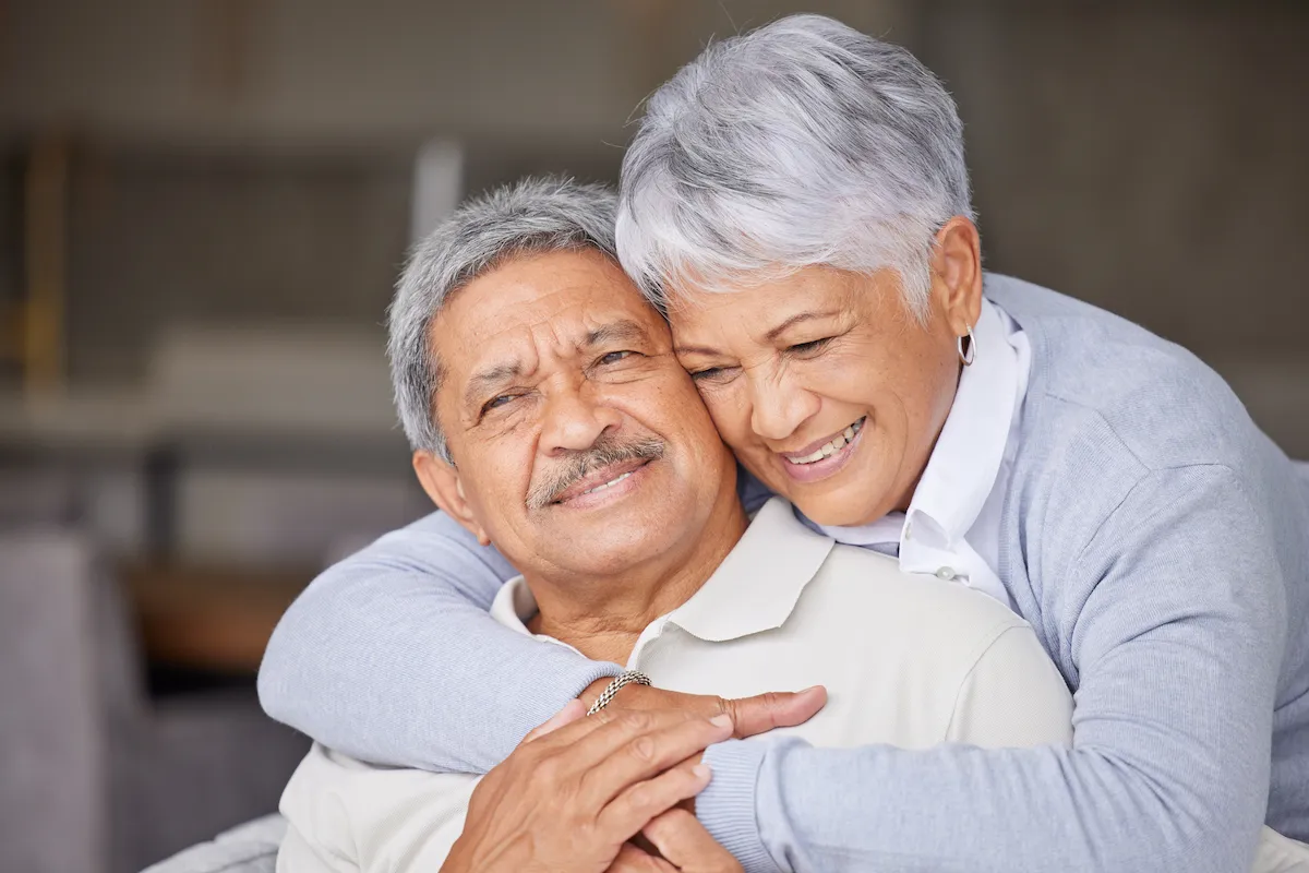 Older woman hugging man from behind