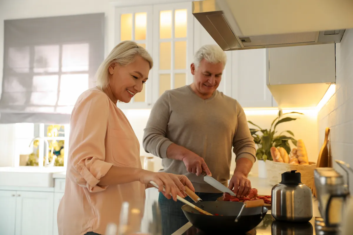 Older man and woman cooking together