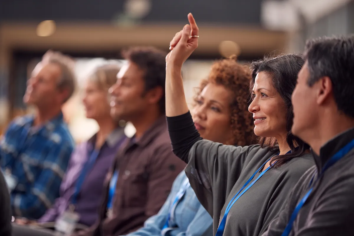 Woman in conference raising her hand