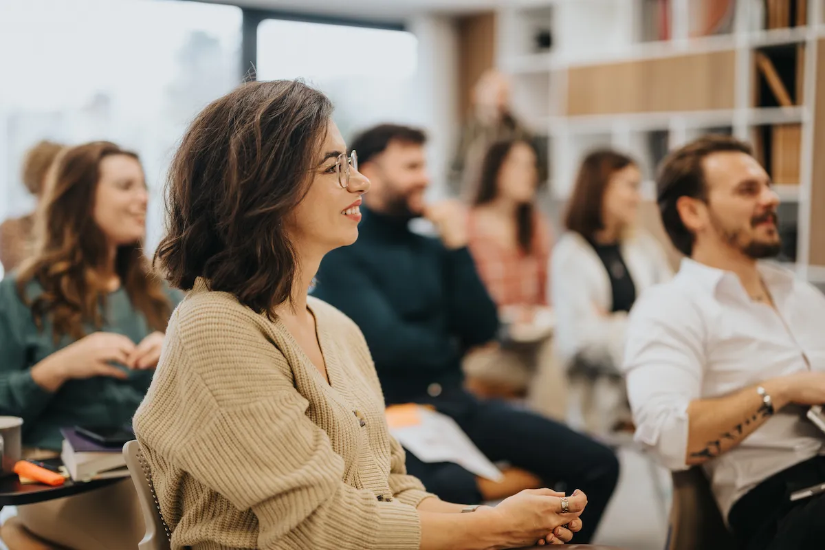 Group of men and women sitting in presentation classroom